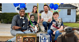 Star Wars characters, both adults and kids, gather with themed toys and big smiles outside a home, as Disney grants a Make-a-Wish child an unforgettable Star Wars adventure.