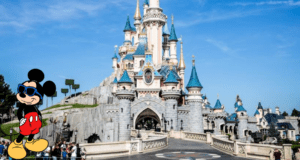Mickey Mouse, sporting cool sunglasses, poses in front of Disneyland’s iconic fairytale castle under clear blue skies. The energy is infectious as fans discuss the latest major policy change sweeping through Disney Park.