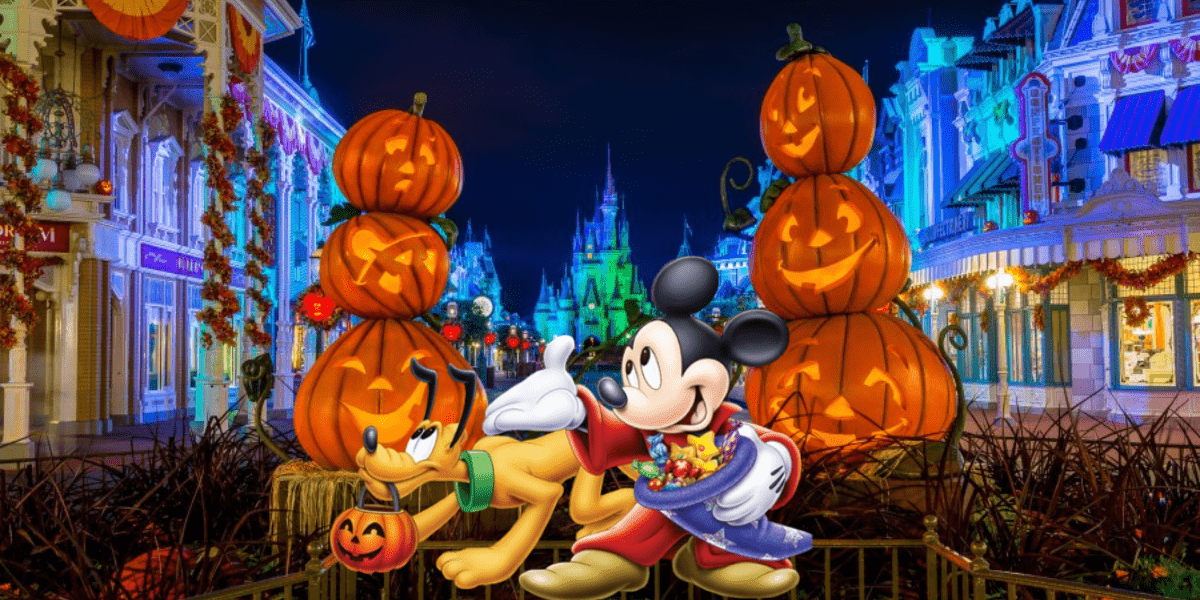 Mickey Mouse and Pluto dressed in Halloween costumes, posing with glowing jack-o'-lanterns along a festively decorated street at night, bringing the magical Halloween ambiance to life at Disney’s Magic Kingdom for guests.