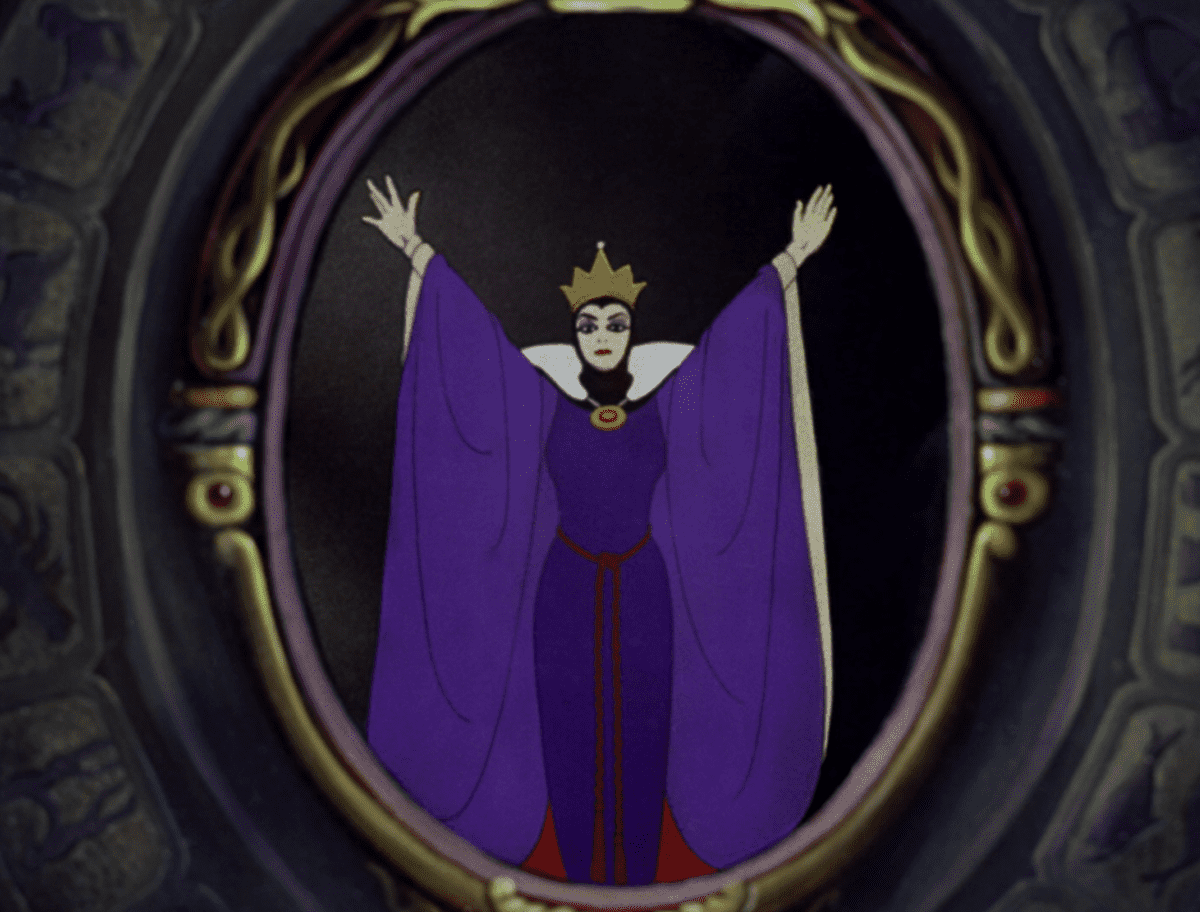 The Evil Queen, dressed in her signature purple robe, raises her arms dramatically inside an ornate oval mirror frame—capturing the magical intrigue surrounding Disney World's legendary lack of mirrors.