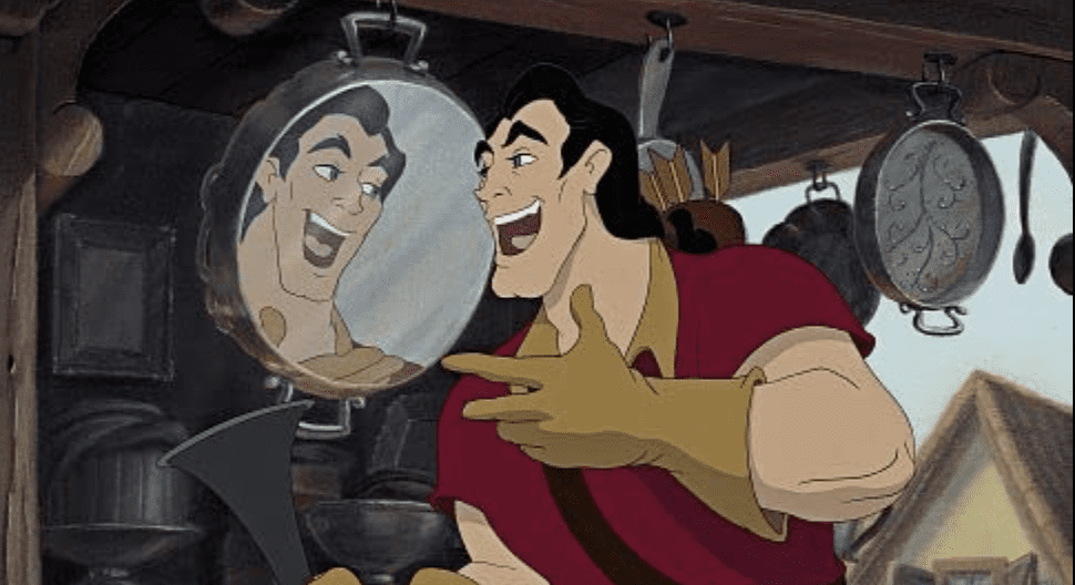 Mickey Mouse grins and gestures toward his own reflection in a shiny metal pan at a bustling market stall, jokingly wondering aloud, “Why are there no mirrors in Disney World?”.