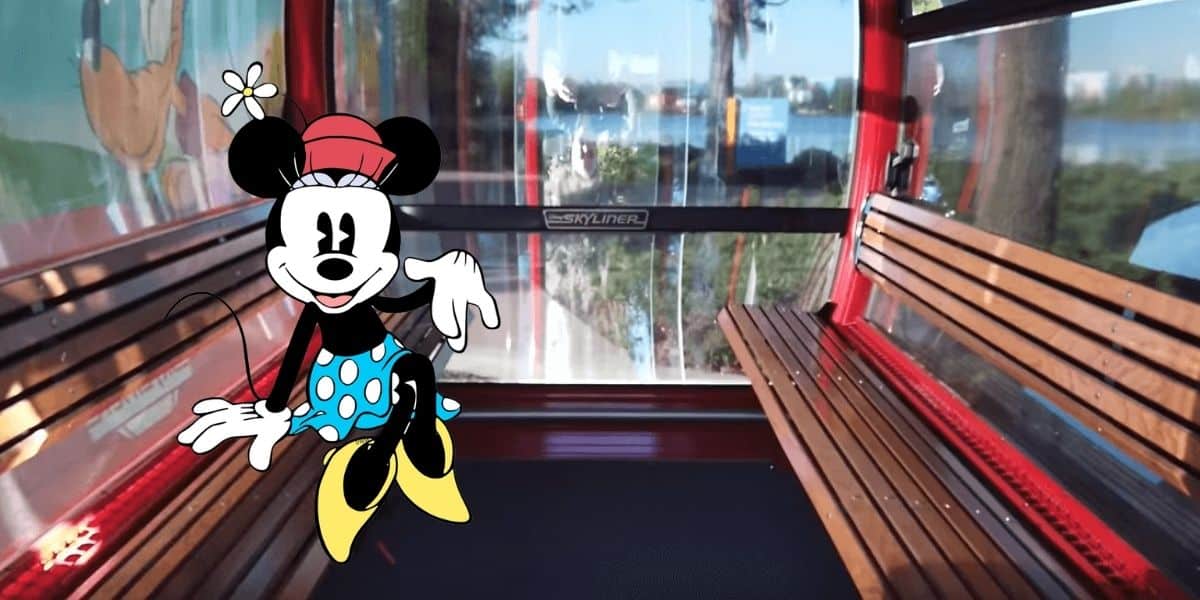 Minnie Mouse enjoys a relaxing moment on a wooden bench inside a bright red Skyliner gondola with expansive windows, capturing the whimsical charm of Disney World’s iconic cable car experience.
