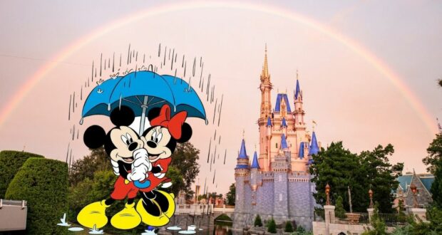 Minnie and Mickey Mouse stand under a blue umbrella with rain falling on them, in front of a castle with blue rooftops and a bright rainbow arching across the sky, capturing the magical weather at Disney World.