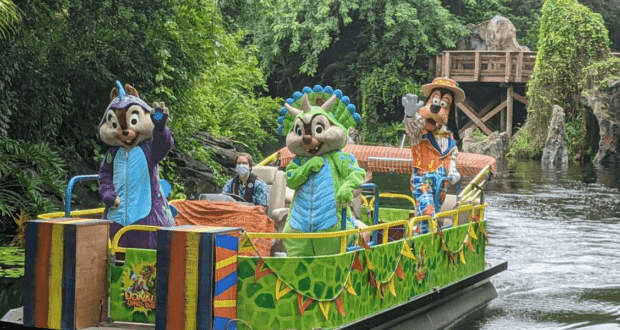 Chip, Dale, and Goofy delight guests as they cruise through lush greenery on a festively decorated boat at the theme park, creating memorable moments for fans reminiscent of classic Character Dining experiences.