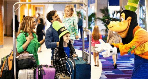 Goofy welcomes a family with their suitcases inside a vibrant Disney World resort, capturing the excitement and magic that make the vacation experience so memorable.