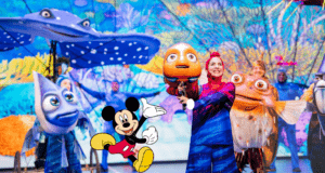 On stage at Disney’s Animal Kingdom, vibrant performers in fish costumes capture the undersea adventure of Finding Nemo: The Big Blue...and Beyond, as Mickey Mouse appears in the foreground to delight the audience and add extra Disney magic.