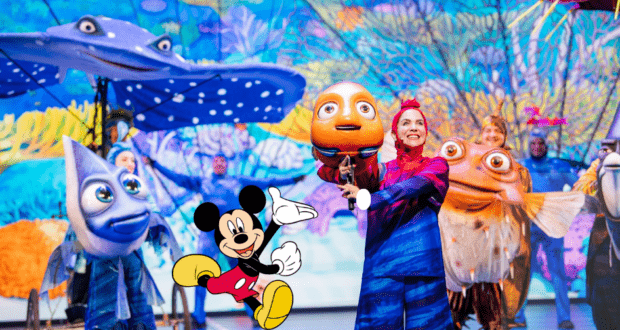On stage at Disney’s Animal Kingdom, vibrant performers in fish costumes capture the undersea adventure of Finding Nemo: The Big Blue...and Beyond, as Mickey Mouse appears in the foreground to delight the audience and add extra Disney magic.
