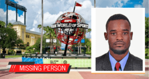A "Missing Person" alert featuring a man's photo appears against the entrance of a major sports arena, spotlighting the urgent disappearance of Haitian Special Olympics Delegates during an international athletic event.