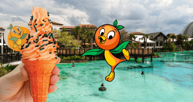 Enjoy a refreshing Orange Bird DOLE Whip ice cream cone beside the waterfront at Magic Kingdom, with the adorable Orange Bird character and enchanted, storybook-style buildings creating a whimsical Disney backdrop.