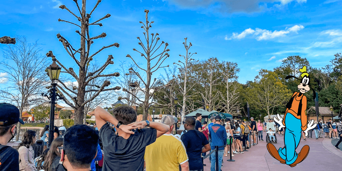 Guests line up outside beneath clear blue skies and leafless trees, with Goofy joining the crowd as everyone eagerly waits to grab a bite at a popular EPCOT quick-service spot.