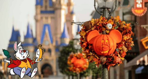 A festive Mickey-shaped pumpkin wreath brightens Main Street near Cinderella Castle, celebrating the enchanting Halloween vibes of Magic Kingdom’s grand opening, while the White Rabbit character from Alice in Wonderland clutches his signature pocket watch nearby.