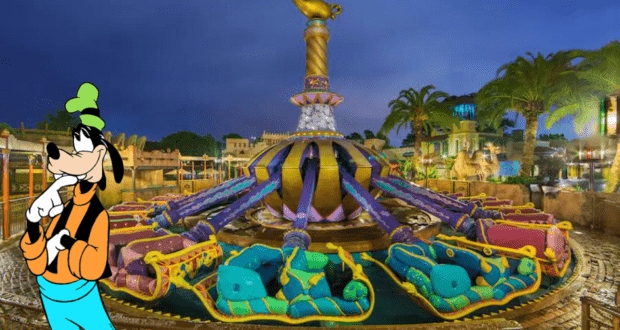Goofy greets guests beside the vibrant, Aladdin-inspired flying carpets attraction at Magic Kingdom, proving that even lesser-hyped rides can shine with magical charm and whimsy after dark.