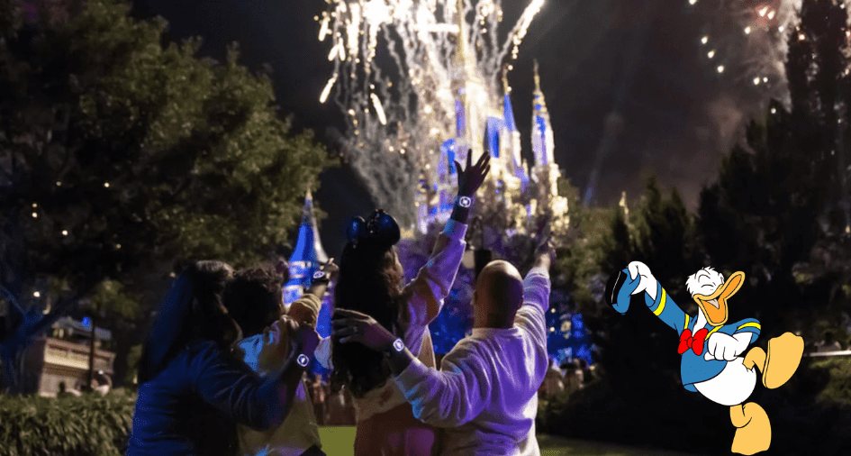 Guests gather in front of Cinderella Castle at Walt Disney World, marveling at a vibrant fireworks display as Donald Duck waves nearby. Their MagicBand+ wristbands light up and pulse in perfect sync with the magical nighttime spectacular.