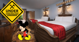 Mickey Mouse appears downcast in a plain hotel room at Disney World, with an 'Under Construction' sign tucked in the corner, clearly missing the whimsical pirate-themed energy once found at Disney's Caribbean Beach Resort.