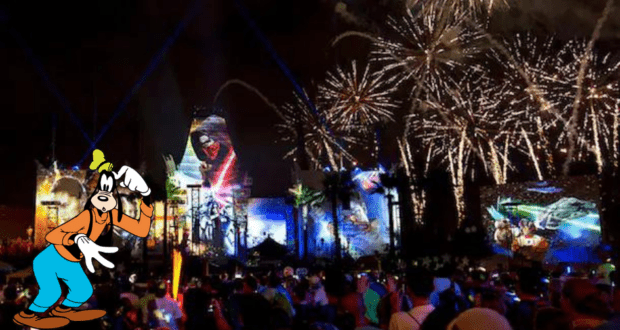 Goofy stands looking bewildered as vibrant fireworks explode and the Star Wars: A Galactic Spectacular nighttime projection show lights up the sky at Disney's Hollywood Studios.