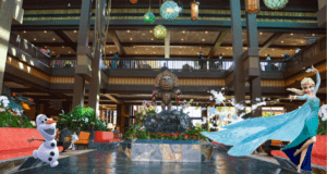 Elsa and Olaf from Frozen greet guests in a tropical-themed Disney Resort lobby, complete with a whimsical tiki statue and signature Disney magic.
