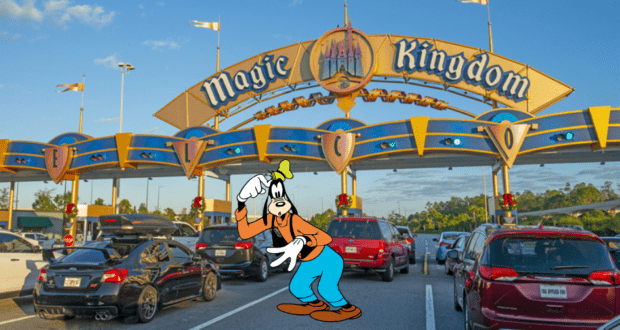 Goofy greets guests among parked cars at Disney World's Magic Kingdom entrance, welcoming everyone with his signature charm on a bright, sunny day.