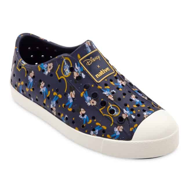 Navy slip-on shoe featuring Disney and Native logos, decorated with playful Mickey Mouse prints and bold yellow highlights—perfect for showing off your Disney fandom while staying comfy during your next adventure at Disney World.