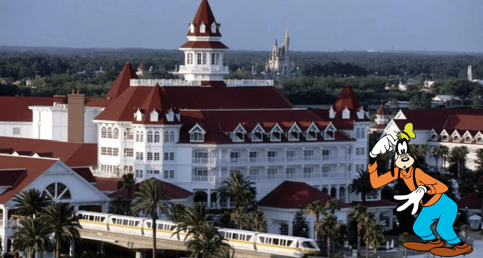 Goofy greets guests in front of Disney’s Grand Floridian Resort as the iconic monorail glides by and Cinderella Castle sparkles in the Magic Kingdom skyline.