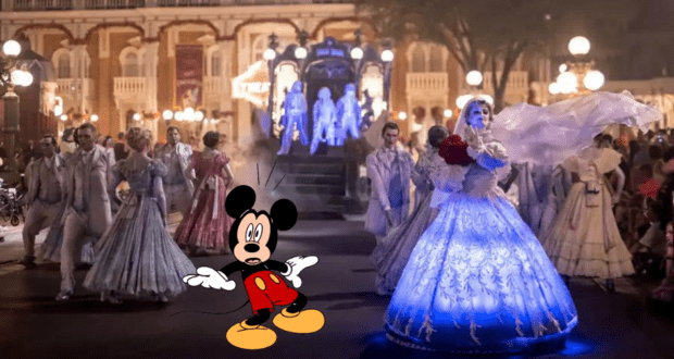 Mickey Mouse greets guests at Disney World's Mickey's Not-So-Scary Halloween Party, standing in front of glowing ghost dancers as they perform during the nighttime parade.
