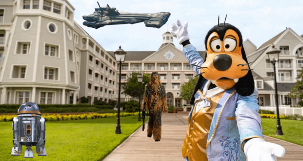 Goofy strikes a playful pose in front of the Galactic Starcruiser hotel, joined by R2-D2 and Chewbacca, with Star Wars spaceships soaring above—capturing the thrilling energy of a visit to this epic Disney experience.