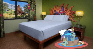 Mickey Mouse relaxes on a rug in a vibrantly decorated Disney World hotel room, surrounded by tropical accents and a plush white bed, savoring some well-deserved downtime away from the parks.