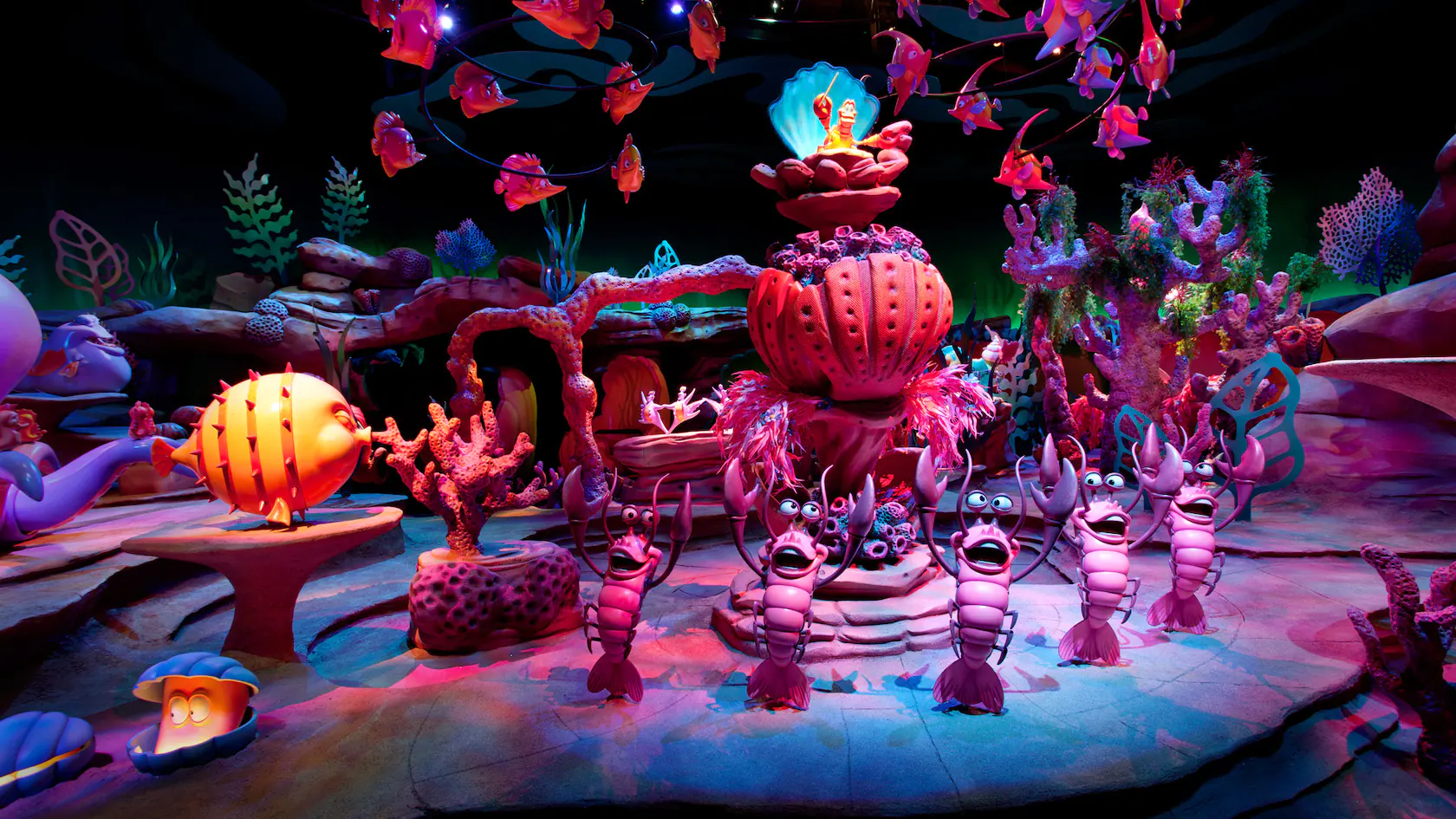 Vibrant undersea world with lively sea creatures and glowing coral, channeling The Little Mermaid ride’s magical Disney energy.