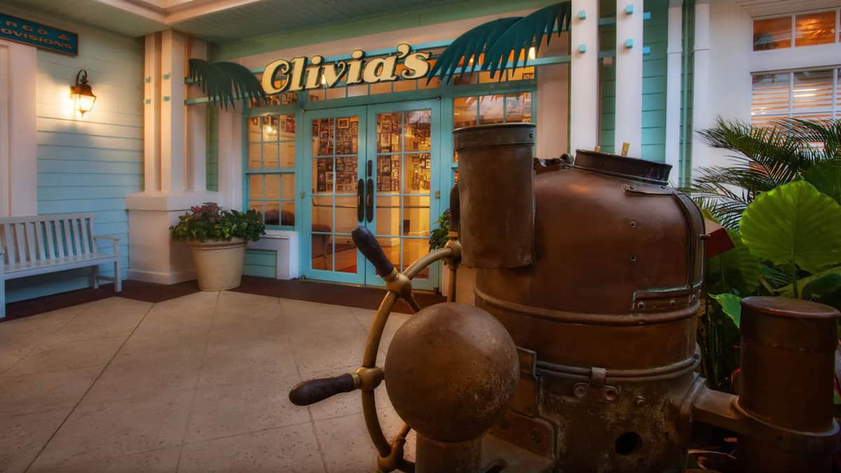 Olivia’s Cafe at Disney's Old Key West Resort greets you with a lively tropical-themed entrance, complete with playful pastel colors and a classic nautical prop that sets the stage for a laid-back island dining experience.