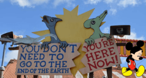 In DinoLand, two friendly cartoon dinosaurs greet visitors with cheerful signs saying, "You don't need to go to the end of the earth" and "You're here now!.