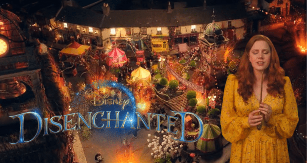 Giselle in a bright yellow dress stands before a lively, storybook-inspired village backdrop, with the "Disney Disenchanted Trailer" title displayed above.