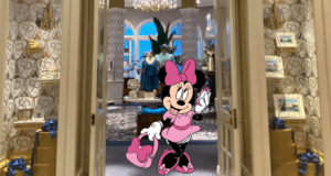 Minnie Mouse, dressed in pink, greets guests at the entrance of a chic boutique at Disney's Grand Floridian Resort, surrounded by exclusive merchandise, festive gift boxes, and stylish apparel displays.