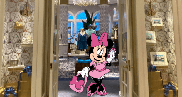 Minnie Mouse, dressed in pink, greets guests at the entrance of a chic boutique at Disney's Grand Floridian Resort, surrounded by exclusive merchandise, festive gift boxes, and stylish apparel displays.