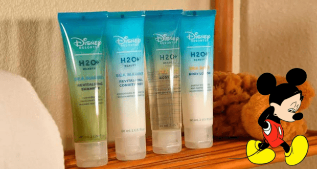 A set of four Disney H2O+ toiletries is perfectly lined up next to a sponge, topped off with Mickey Mouse appearing in the bottom right corner to add that signature Disney magic to your resort bathroom essentials.