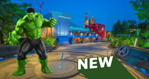 Hulk towers in front of Avengers Campus at night, with a bold green "NEW" banner announcing the arrival of the immersive Hulk experience for Avengers fans.