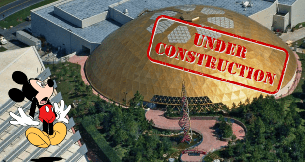 Aerial view of EPCOT's Play Pavilion under its signature dome with a bold "UNDER CONSTRUCTION" sign, as a surprised Mickey Mouse reacts nearby.