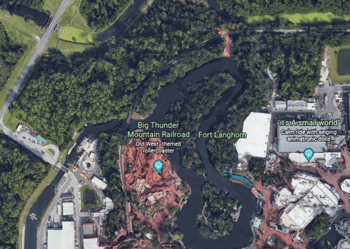 Bird’s-eye view of the theme park with classic attractions such as Big Thunder Mountain and D23 Beyond Thunder Mountain, winding rides, and lush greenery surrounding each immersive land.