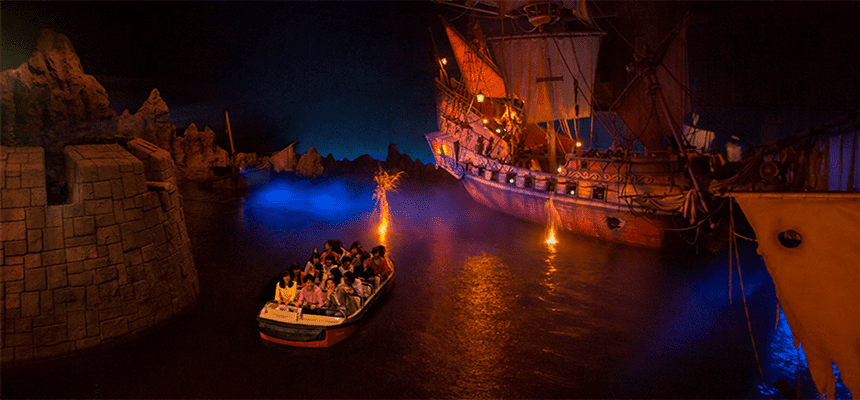 Guests embark on a boat adventure, gliding past an imposing pirate ship and fortress under dim lighting, fully immersed in the cinematic world of Pirates of the Caribbean at Tokyo Disney Resort.