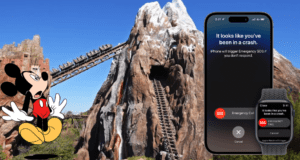 Mickey Mouse at Disney World stands by a thrilling rollercoaster, holding an iPhone and wearing a watch, both flashing SOS crash detection alerts, demonstrating how iPhone Crash Detection can enhance guest safety in the park.