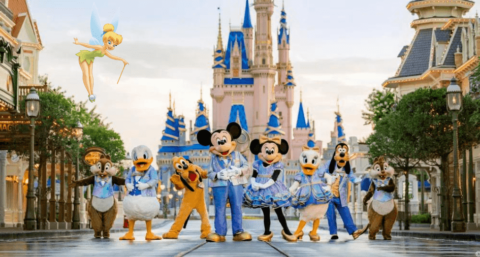 Mickey Mouse, Minnie, Goofy, and other beloved Disney characters gather in front of Cinderella Castle as Tinker Bell soars overhead under clear blue skies. The magic stretches into the night with dazzling experiences during Disney World’s Extended Evening Hours.