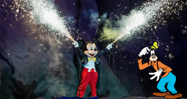 Mickey Mouse lights up the Fantasmic stage with sparklers, while Goofy waves enthusiastically from the corner, delighting Disney World guests.