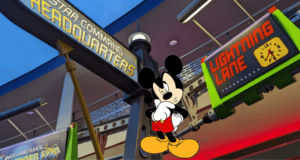 Mickey Mouse welcomes guests at the entrance to Star Command Headquarters, standing near Lightning Lane signs as fans kick off their Disney World adventure with Disney Genie.