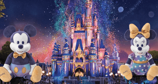 Mickey and Minnie plush toys pose in front of Cinderella Castle, illuminated with dazzling lights and vibrant fireworks overhead, celebrating the enchanting atmosphere of the Walt Disney World 50th Anniversary Scentsy event.