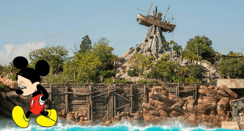Mickey Mouse strolling in front of Disney’s Typhoon Lagoon, with the iconic shipwreck perched atop Mount Mayday and vibrant refurbishments underway, radiating excitement for theme park fans.
