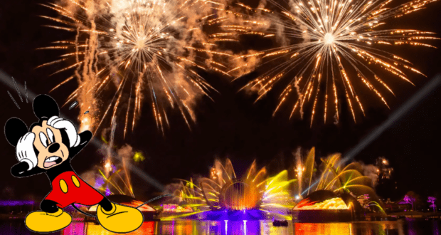 Mickey Mouse appears amazed as dazzling, colorful fireworks explode above the Epcot Harmonious nighttime spectacular at Disney World.
