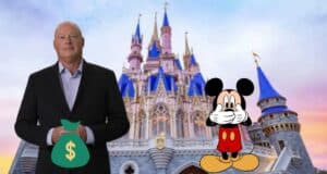 Bob Chapek in front of Cinderella Castle with Mickey holding his mouth.