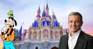 Bob Iger in a sharp suit stands with Goofy in front of the iconic Disney castle, glowing at sunset.