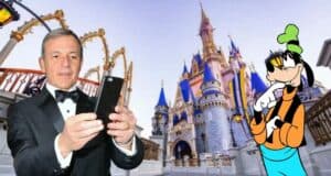 A guest dressed in a tuxedo snaps a selfie with Goofy in front of the iconic castle at Walt Disney World, commemorating the magical experiences made possible by Bob Iger’s innovations like theme park reservations.