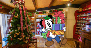 Minnie Mouse, festive in her Santa hat, delights guests as she carries presents through a beautifully decorated Christmas shop filled with twinkling ornaments and a sparkling tree, surrounded by exclusive Disney holiday merchandise and whimsical Disney souvenirs in the heart of the park.