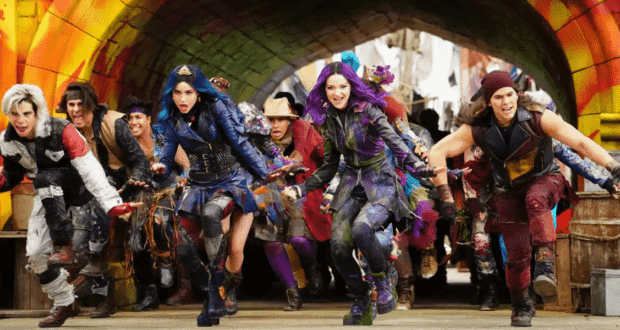 Teens in vibrant, punk-inspired outfits dash with excitement beneath a dramatic archway, eager to dive into the adventure and thrills of Disney Villains Land.