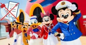 Mickey Mouse, Minnie Mouse, Goofy, Donald Duck, and Pluto dressed in nautical attire pose together on the deck of a Disney Cruise Line ship; nearby, a Disney Cruise Line COVID-19 test appears with a red "X" over it.